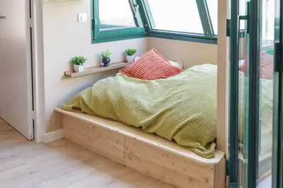 a bed sitting on a wooden bench in a room at Nice Renting - FLEURS - Luxury Stay Terrace Quiet Private Parking in Nice