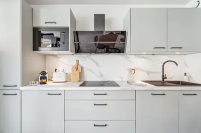 a white kitchen with white cabinets and a sink at Nice Renting - FLEURS - Luxury Stay Terrace Quiet Private Parking in Nice