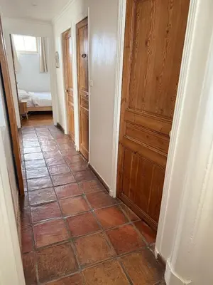 a hallway with a tiled floor and a wooden door at maison de charme piscine au bord de mer in Cagnes-sur-Mer