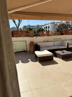 a patio with couches and tables on a roof at maison de charme piscine au bord de mer in Cagnes-sur-Mer