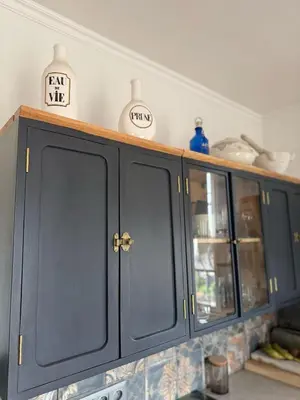 a kitchen counter with black cabinets and dishes on it at maison de charme piscine au bord de mer in Cagnes-sur-Mer