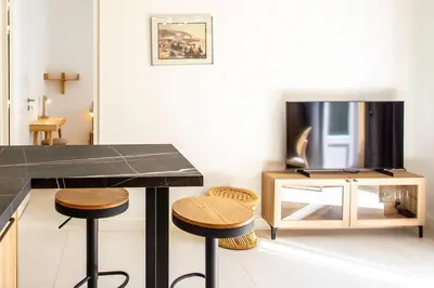 a kitchen with a counter and stools and a tv at #35 Suite Carlone 5min from the beach AC & Terrace in Nice