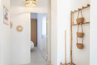 a hallway with white walls and a hallway with baskets on the wall at #35 Suite Carlone 5min from the beach AC & Terrace in Nice