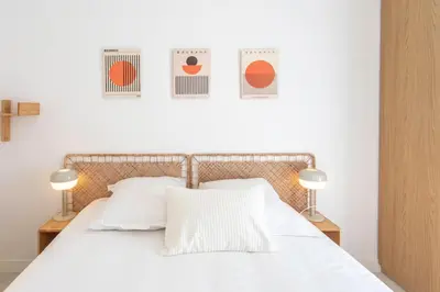 a bedroom with a white bed with three pictures on the wall at #35 Suite Carlone 5min from the beach AC & Terrace in Nice