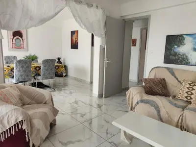 a living room with two couches and a table at Spacieux 3 chambres et balcon in Nice