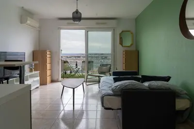 a living room with a couch and a table at Studio équipé dans une résidence avec piscine à 10mn du centre ville in Nice