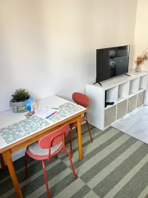 a living room with a table and a tv at Charmant studio moderne équipé à Nice in Nice