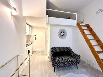 a living room with a chair and a staircase at City Center Studio - 1 min Train Station & Main Street in Nice