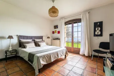 a bedroom with a bed and a large window at Magnifique villa avec vue mer panoramique in Nice