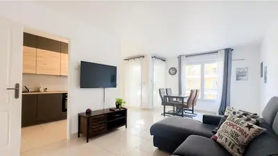 a living room with a couch and a table and a kitchen at nice two rooms in Nice