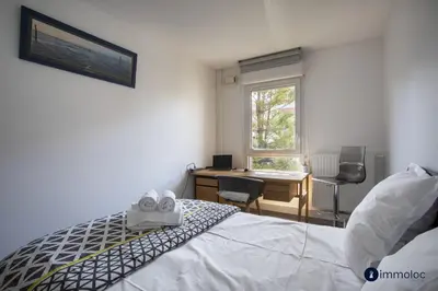 a bedroom with a bed and a desk and a window at Air-conditioned apartment near Libération district in Nice