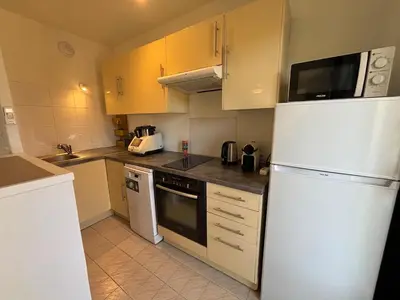a kitchen with white appliances and a white refrigerator at Cozy Apt with balcony - Garibaldi Port in Nice