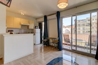 a kitchen with a counter and a large window at Cozy Apt with balcony - Garibaldi Port in Nice