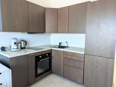 a kitchen with wooden cabinets and a sink and a dishwasher at Appartement SEA-Azur panorama Nice Fabron in Nice