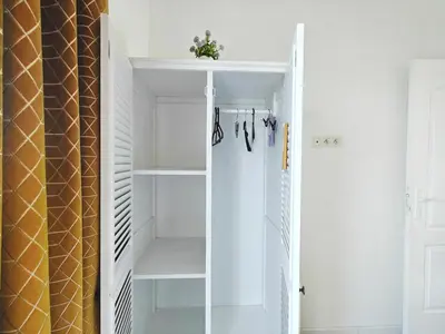 a walk in closet with white shelves and a curtain at Appartement SEA-Azur panorama Nice Fabron in Nice