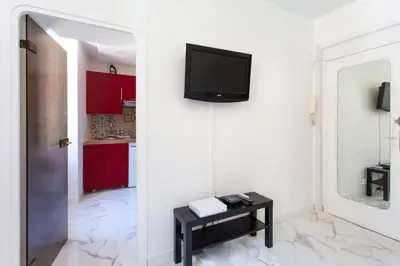 a living room with a tv on a white wall at LYMPIA -Cosy studio, 200 m plages de Nice - Le Port in Nice