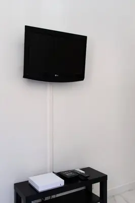 a flat screen tv hanging on a white wall at LYMPIA -Cosy studio, 200 m plages de Nice - Le Port in Nice