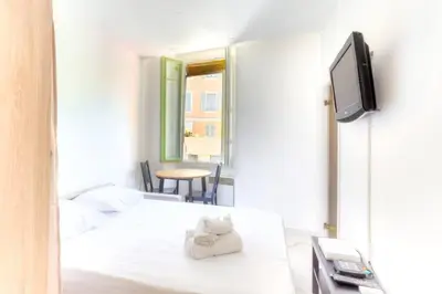 a hotel room with two beds and a tv at LYMPIA -Cosy studio, 200 m plages de Nice - Le Port in Nice