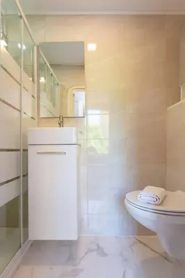 a white bathroom with a toilet and a staircase at LYMPIA -Cosy studio, 200 m plages de Nice - Le Port in Nice