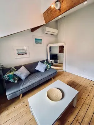 a living room with a table and a couch at Guisol 17 Attic cocon Port de Nice in Nice