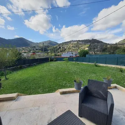 a chair sitting on a patio with a yard at Le flamand in Tourrette-Levens
