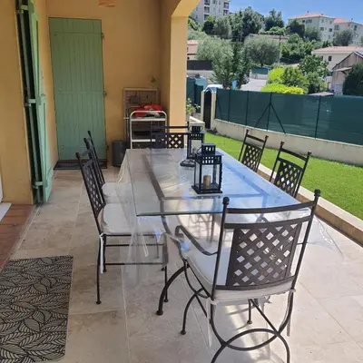 a glass table and chairs on a patio at Le flamand in Tourrette-Levens