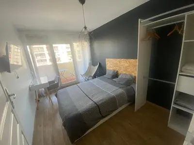 a bedroom with a bed and a desk and a window at Appartement de 4 chambres proche plage, tram et aeroport in Nice