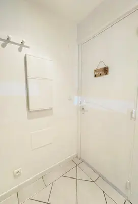 a white door in a room with a tile floor at Cozy studio sur la promenade in Nice