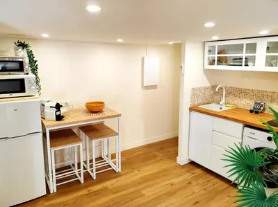 a kitchen with white cabinets and a counter top at Tribord Holiday House in Nice