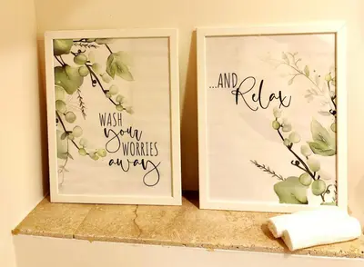 two picture frames sitting on a shelf with flowers at Tribord Holiday House in Nice