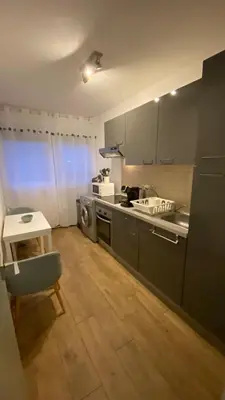 a kitchen with a counter and a table and a stove at Appartement proche plage, aéroport, tram in Nice