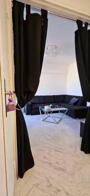 a living room with black curtains and a couch at Top Floor with Sea View, Clim and Veranda in Nice