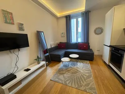 a living room with a couch and a flat screen tv at 2P place massena in Nice