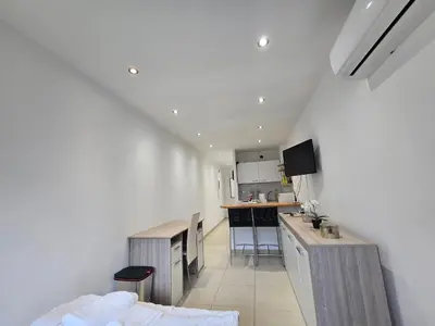 a living room with a kitchen with a counter and a kitchen at Sunny Prom Studio in Nice