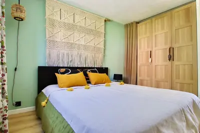 a bedroom with a large bed with yellow pillows at Panoramic sea view of the French Riviera, Parking in Nice