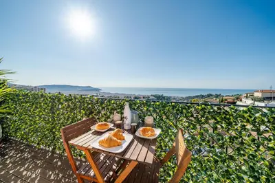 a living room with a couch and a large window at Panoramic sea view of the French Riviera, Parking in Nice