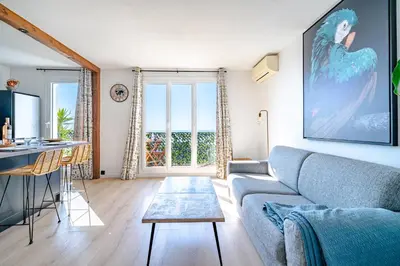 a living room with a couch and a table at Panoramic sea view of the French Riviera, Parking in Nice