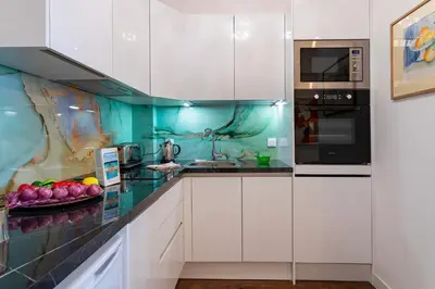 a kitchen with white cabinets and a plate of fruit on the counter at LE ROYAL AP4456 by Riviera Holiday Homes in Nice