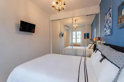 a bedroom with a large white bed and a mirror at LE ROYAL AP4456 by Riviera Holiday Homes in Nice