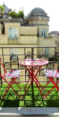 a red table and two chairs on a balcony at LE ROYAL AP4456 by Riviera Holiday Homes in Nice