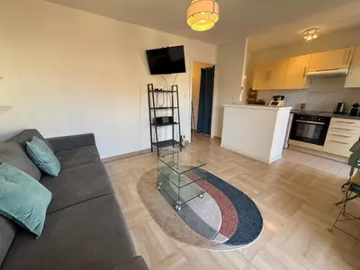 a living room with a couch and a kitchen at Cozy Studio Apt with balcony close to Garibaldi in Nice