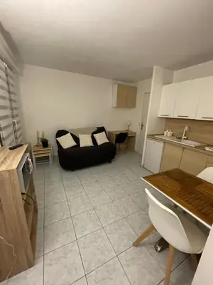 a living room with a black couch and a kitchen at Studio 200m mer et promenade des anglais in Nice