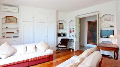 a living room with a white couch and a table at Residence les Lauriers in Nice