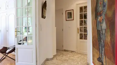 a hallway with a door and a painting on the wall at Residence les Lauriers in Nice