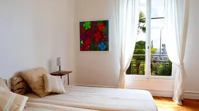 a bedroom with a large bed and a window at Residence les Lauriers in Nice