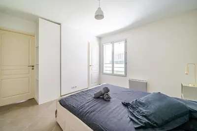 a teddy bear sitting on a bed in a bedroom at Cozy 2P Port de Nice garage in Nice