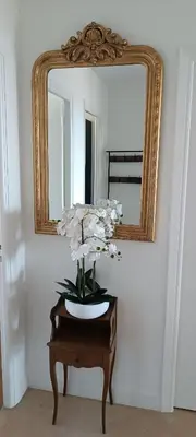 a mirror and a vase with flowers on a table at Appartement vue mer et panoramique, 2 chambres, 3 lits in Nice