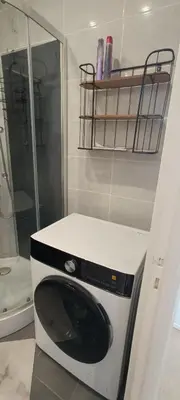 a washing machine in a bathroom with a shower at Appartement vue mer et panoramique, 2 chambres, 3 lits in Nice