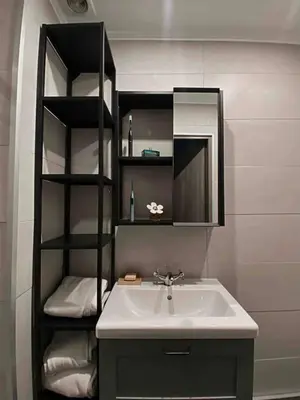 a bathroom with a sink and a shelf with towels at Nice centre studio rénové avec emplacement central in Nice