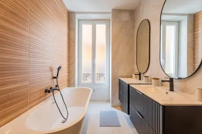 a bathroom with a tub and two sinks and a mirror at Charme et confort - centre ville de Nice in Nice